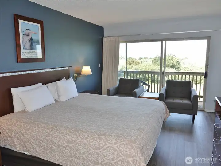 Studio unit w/ king-sized bed and LVP flooring.