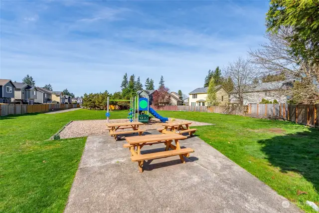 The neighborhood community park includes picnic tables and a play area.