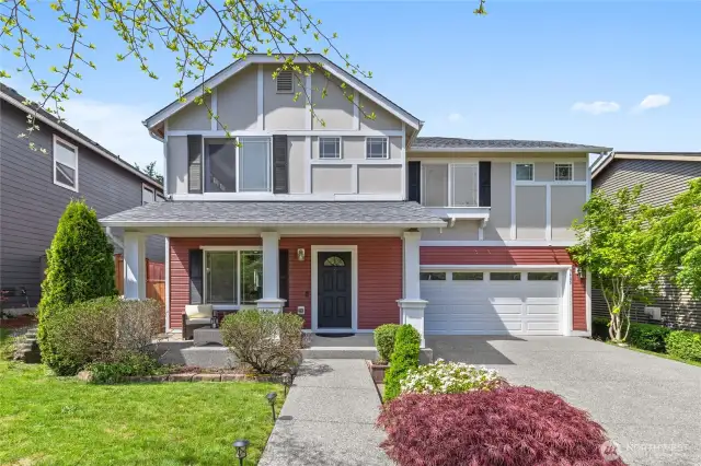 craftsman home with front patio, two car garage, private walkway and front lawn with landscaping.