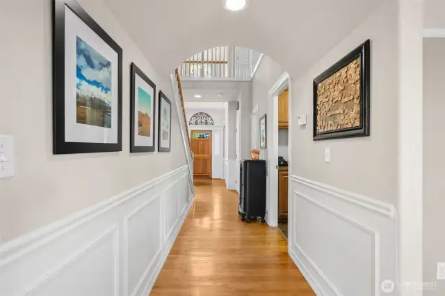 Hallway off of the main floor that leads to the laundry room, garage, and downstairs half bath