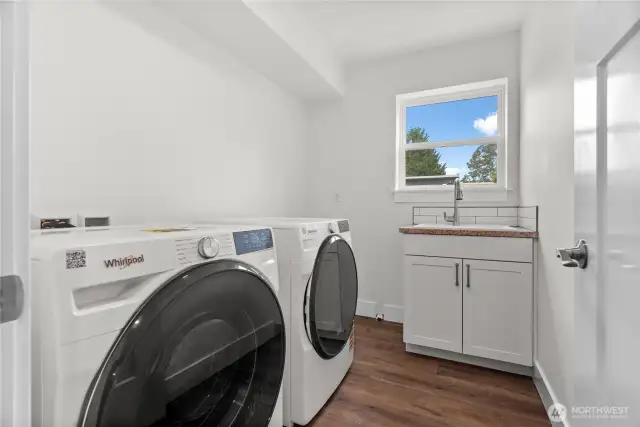 Laundry room featuring a brand new washer and dryer.