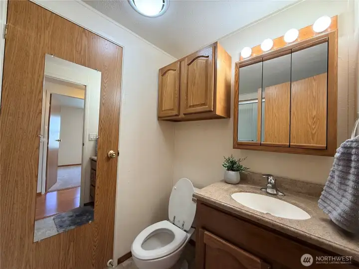 Guest bathroom, which has a passthrough to the utility room/kitchen.