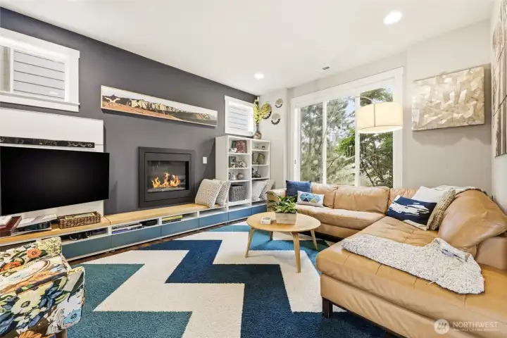 Stunning living room with designer paint colors, warm fireplace and cool, built-in shelving system.