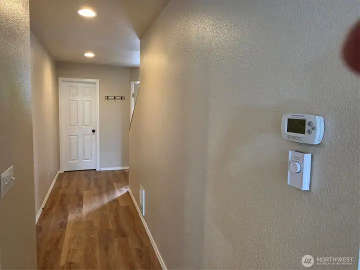 Main Floor hallway with garage door to left , door to 1/2 bath and entrance to right and stairs to upper floor. Main Floor hallway with garage door to left , door to 1/2 bath and entrance to right and stairs to upper floor.