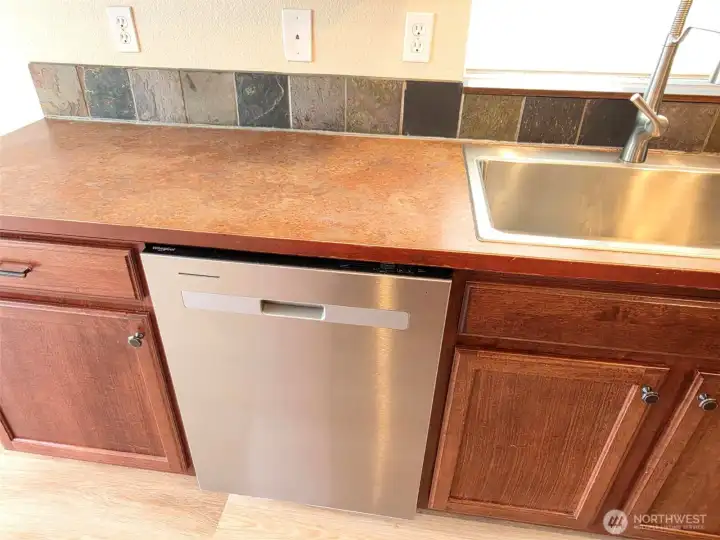 Dishwasher & kitchen sink with window above. Dishwasher & kitchen sink with window above.