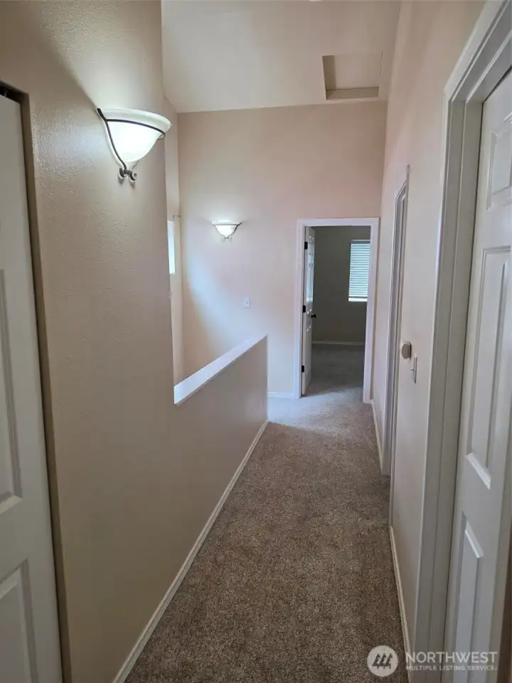 Upper floor hallway with open door to primary bedroom suite and 2 bedoom's to right. Upper floor hallway with open door to primary bedroom suite and 2 bedoom's to right.