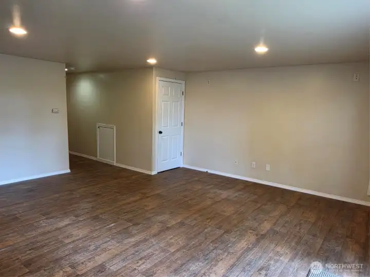 Family Room looking at hallway from stairway and 1/2 bath. Door is to hot water heater and small door is for under stairs storage. Family Room looking at hallway from stairway and 1/2 bath. Door is to hot water heater and small door is for under stairs storage.