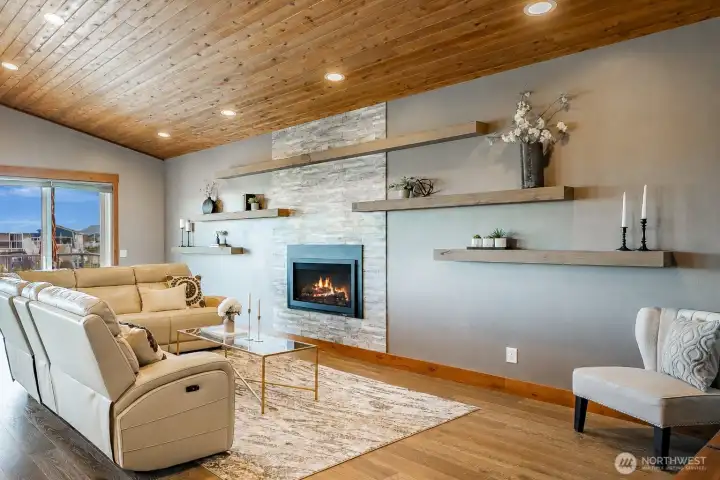 Cozy Living Room with fireplace, tile surround, and beautiful floating shelves.