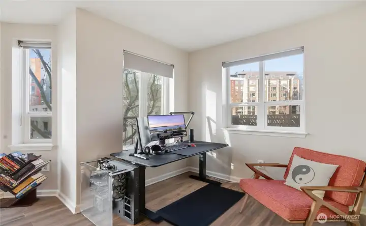Living room with gas fireplace and floor to ceiling windows. Windows have remote control blinds. Updated LVP flooring.