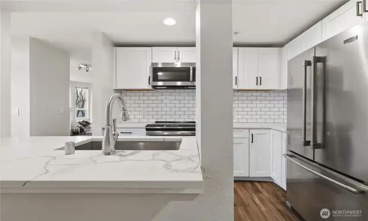 Updated kitchen with stainless steel appliances and quartz countertop.