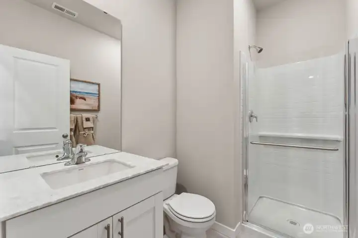 Three-quarter bathroom on main with shower. Photo rendering is representational and may be virtually staged. Actual home is under construction and finishes, elevation, and paint colors may vary. See site agent for details. Three-quarter bathroom on main with shower. Photo rendering is representational and may be virtually staged. Actual home is under construction and finishes, elevation, and paint colors may vary. See site agent for details.