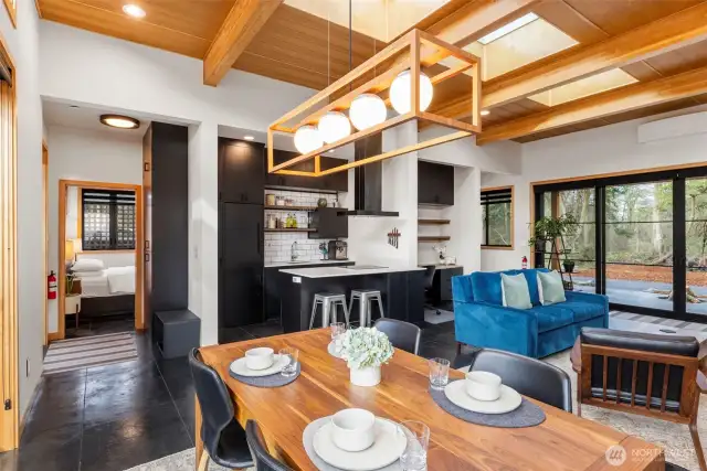 Stepping back into the home, with the kitchen straight ahead and the primary bedroom to the left, the layout of the home has been thoughtfully designed for the perfect flow. Note the custom lighting throughout.