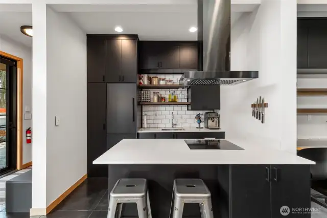 The huge kitchen island anchors this space, with Silestone counters and quality built-in Fisher & Paykel appliances.
