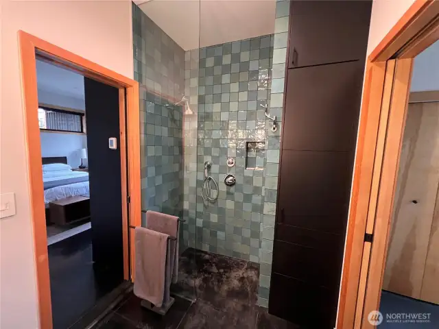 The spacious curbless shower is a spa-like experience, featuring gorgeous hand-glazed tile, and highest quality Brizo fixtures. The tower of cabinetry provides plenty of space for storage.