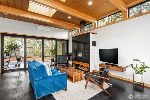 This fabulous living area is flooded with natural light from walls of windows and oversized sliders, to clerestory windows and huge skylights above. Note the mini-split unit mounted above the slider for addtional comfort.