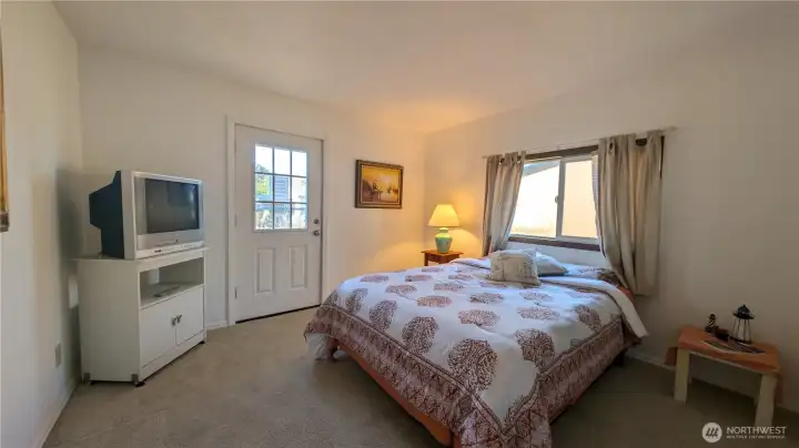 Primary bedroom with exterior door to small deck.