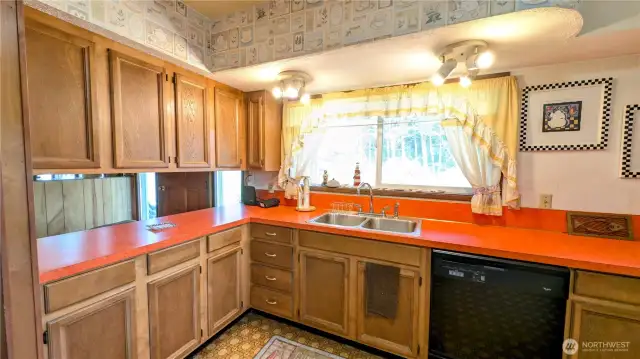 Bright and colorful kitchen with picture window facing the yard.