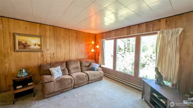 Paneled open concept living room with dining area.
