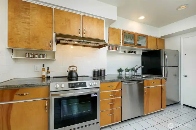 Large kitchen with prep island, sunny breakfast nook, abundant cabinetry, and ample counter space. Ideal for home chefs with easy access to the backyard patio for seamless indoor-outdoor living.