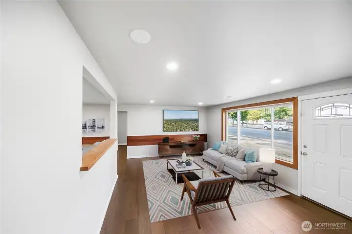 Sunlight pours through the large front window, filling the living room with warmth and brightness. *virtually staged*