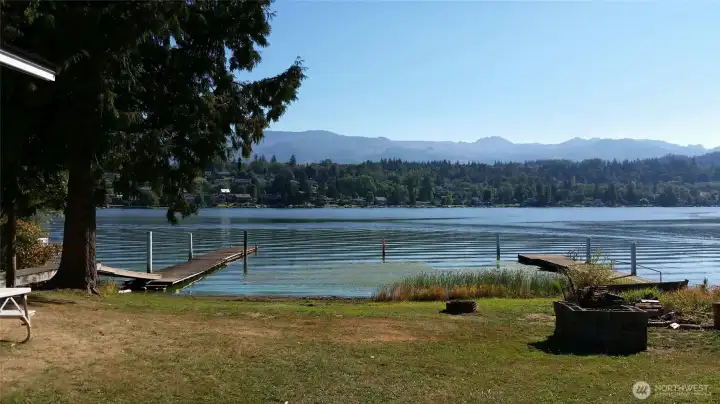 Concrete block area for salmon cooking on right and the fire pit for relaxing evenings. Property dock is on the left.