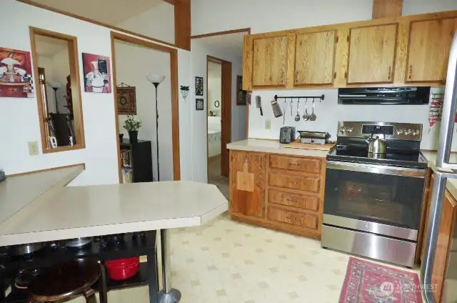 Kitchen with newer stove and lots of cabinets.