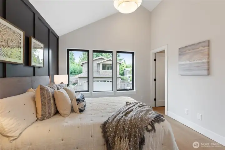 This spacious bedroom combines soft neutrals and bold accents, with a vaulted ceiling and natural light creating a serene, elevated retreat.