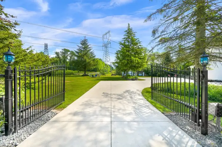 Black iron fencing and coded power gate create an elegant entrance to the property
