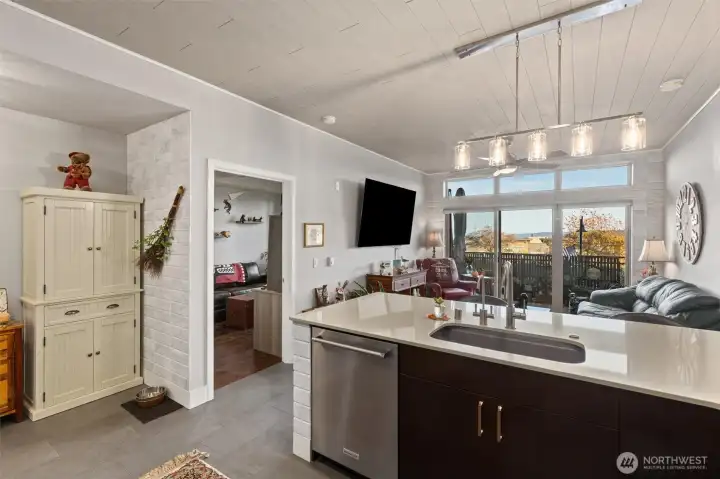 Gorgeous kitchen with modern finishes, 6-burner gas stove, glass tile backsplash, quartz countertops and eating bar. Notice the custom accent tile on the end of the countertop and the ceilings!