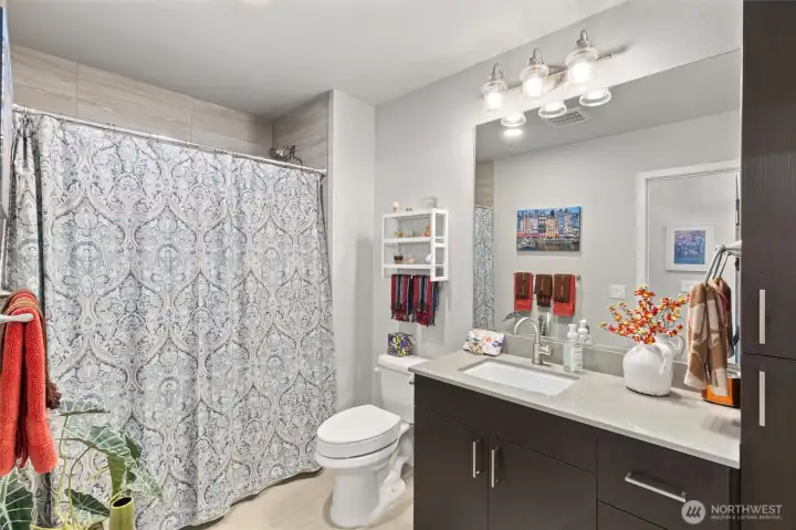 @nd full  bathroom with fully tiled shower surround, quartz countertops and a very euro modern feel.