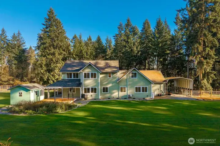 Back of the home. Doesn't evenn show everything like the chicken coop etc. Notice the heated & A/C she shed.  RV Parking area on the right side.