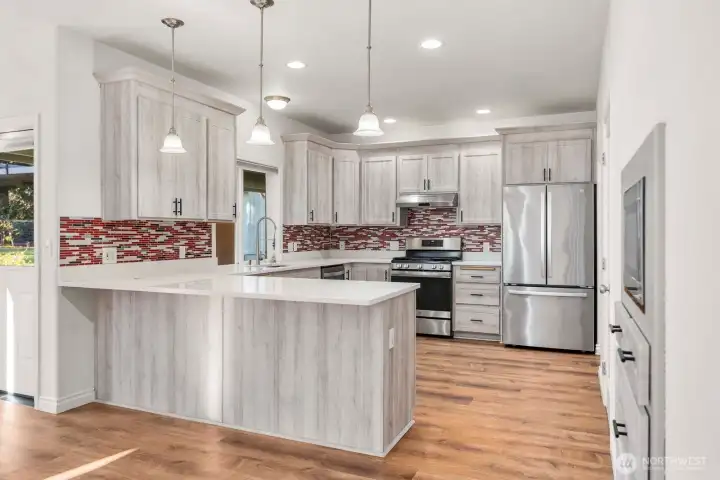 Overview of the kitchen where the cabinets were just refaced and a new backsplash added. (25k) Complete with soft close cupboards and a walk in pantry.