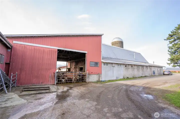 View of exterior milking parlor attached to the hip-roof barn