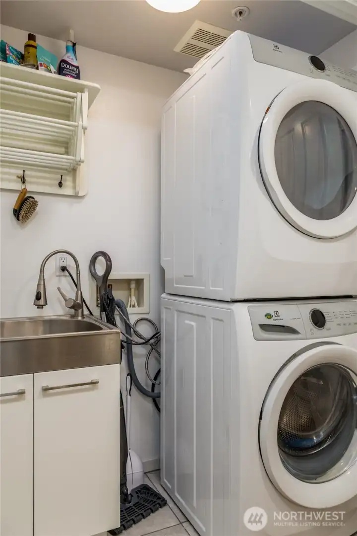 Efficient laundry space includes an exclusive utility sink upgrade, a rare and valuable feature for this floor plan. Stackable washer and dryer go with sellers.