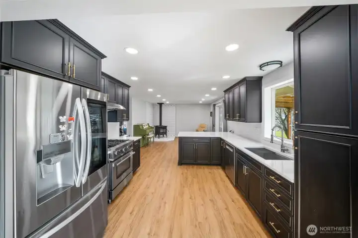 Gorgeous and tastefully updated kitchen showcases ebony black cabinetry with handsome brass hardware. All appliances are inlcluded