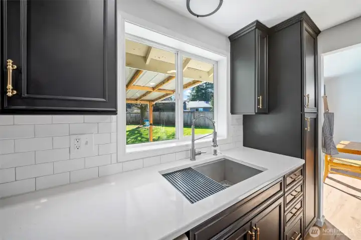 Oversize undermount sink with newer fixtures enjoys views to the rear yard, to keep an eye on things!