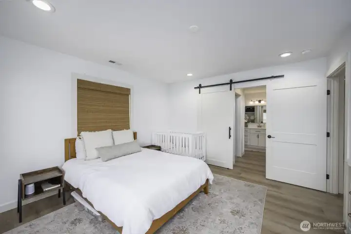 Notice the custom barn door that opens to the bathroom with a walk-in closet to the left