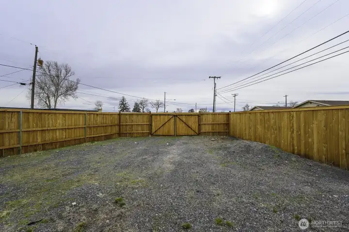 This graveled area is perfect for any parking or storage needs.  The double gate opens wide for a variety of needs