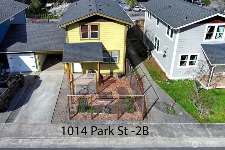 Front of townhouse. Deer proof fenced area for flower and veggie garden. Single car attached garage. Community walkway next to house that accesses Guard Street and directly across from San Juan Library.
