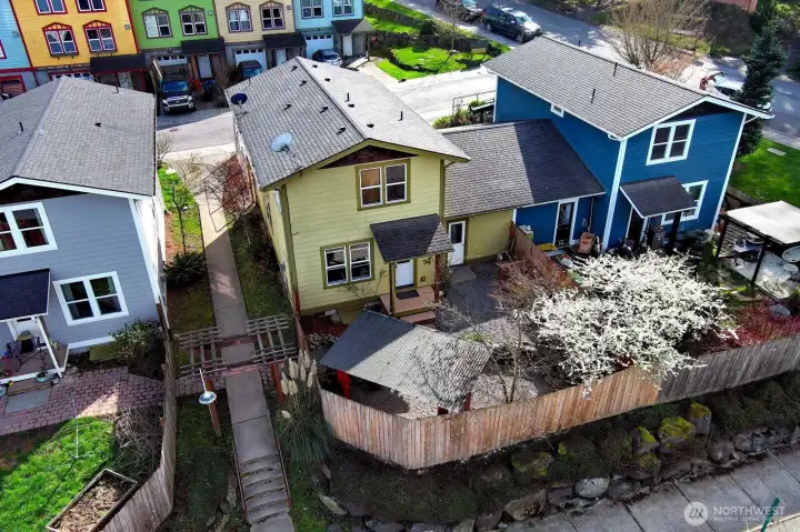 Aerial view of back of townhouse showing fenced area. Backyard has a circulating pond.