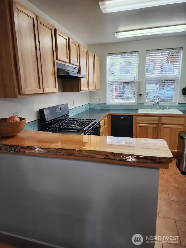 View to kitchen from dining area. Custom built Live-Edge" serving counter.