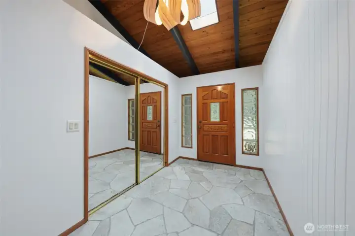 Spacious foyer with soaring wood-plank ceilings and ample natural light.