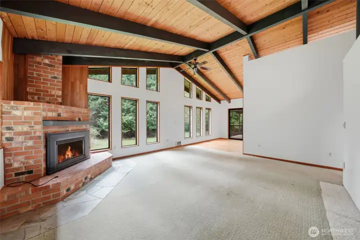 Open-concept living space highlights the dramatic vaulted wood ceilings.