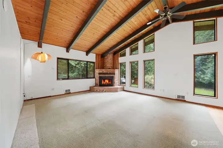 Great room boasts floor-to-ceiling windows and a cozy brick fireplace.