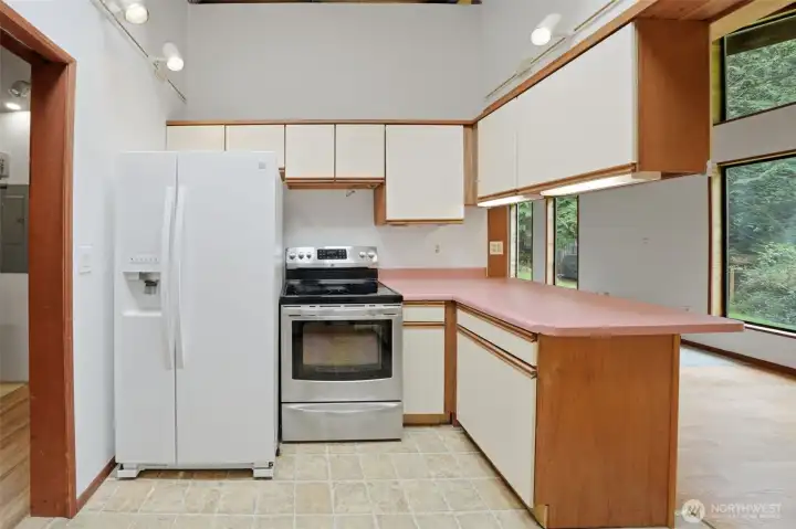 Kitchen offers a clean layout with classic white cabinetry and easy access to the deck.