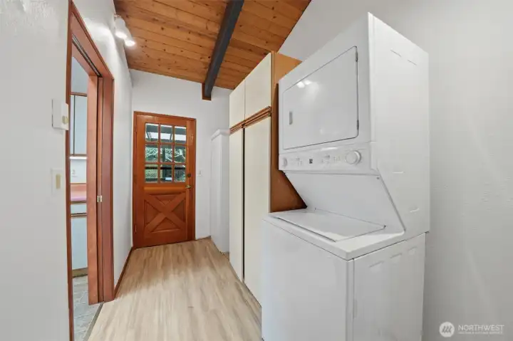 Dedicated laundry room with built-in storage and convenient exterior access.