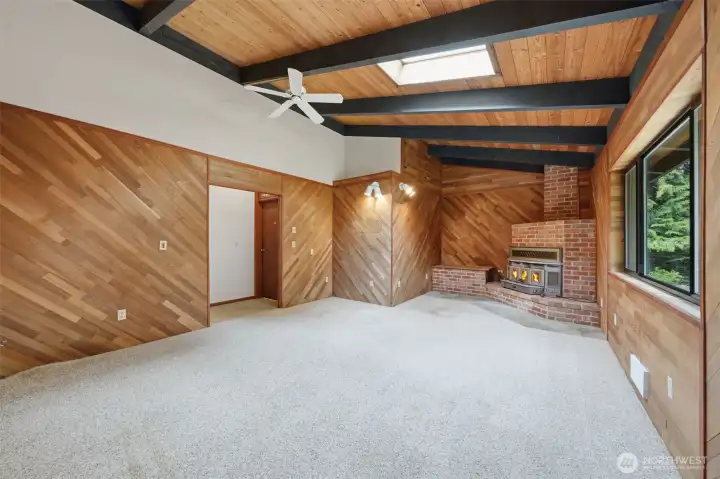 Primary bedroom features warm wood tones, vaulted ceilings, and plush carpeting