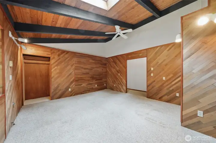 Generous bedroom size with unique wood-paneled accent walls.