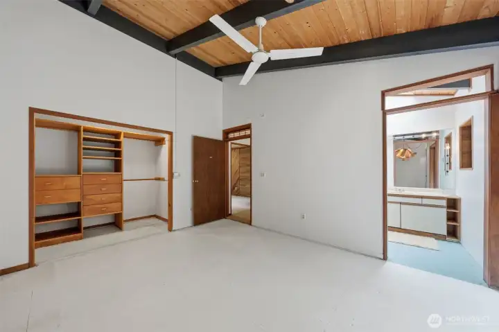 Additional bedroom with built-in shelving and architectural ceiling details.
