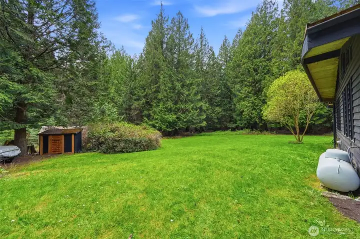 Lush, level backyard framed by mature timber offers a serene escape and plenty of room to roam.